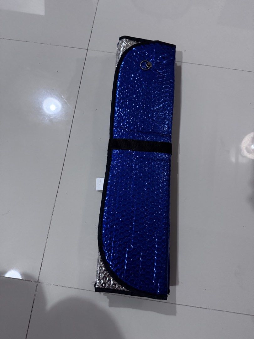 Foldable Windshield Sun Shade (Category: Other Automotive Parts and Accessories) located in Taguig. Submitted by xervin (Listing ID 1469268464, Image 1). Description: - Item: Foldable Windshield Sun Shade - Color: Blue exterior with reflective silver interior - Material: Bubble foil insulation for maximum heat protection - Design: Foldable accordion style with securing strap for easy storage - Condition: Good as new, clean and ready to use - Func