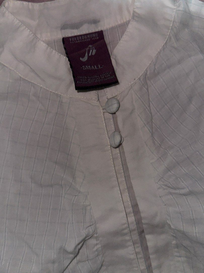 Folded & Hung White Plaid Button-Down Blouse 🤍 (Category: Blouses) located in Valenzuela. Submitted by prelovedbykkaisha (Listing ID 1469226262, Image 3). Description: Size: Small Color: White with subtle plaid stripes Design: Ruffled short sleeves, collar, and front buttons Condition: Like new Perfect for a cute, clean-girl, or coquette-inspired outfit! Can be paired with jeans, skirts, or trousers. 💌.