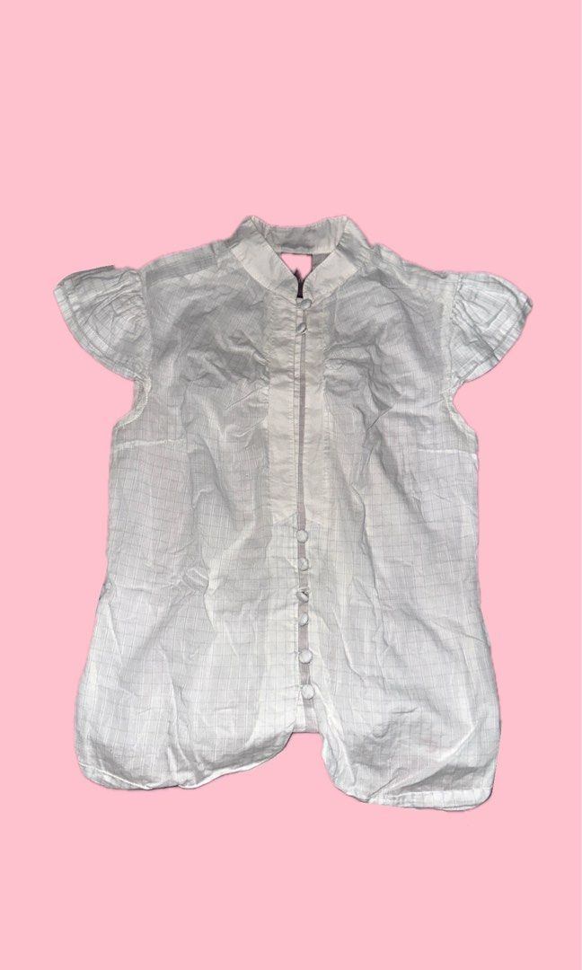 Folded & Hung White Plaid Button-Down Blouse 🤍 (Category: Blouses) located in Valenzuela. Submitted by prelovedbykkaisha (Listing ID 1469226262, Image 1). Description: Size: Small Color: White with subtle plaid stripes Design: Ruffled short sleeves, collar, and front buttons Condition: Like new Perfect for a cute, clean-girl, or coquette-inspired outfit! Can be paired with jeans, skirts, or trousers. 💌.