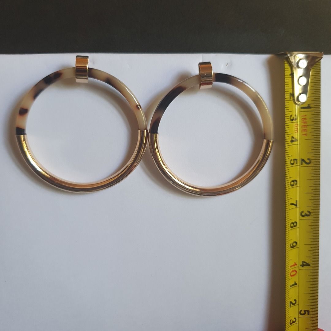 Forever 21 Gold and Brown Tortoise Shell Like Earrings (Category: Earrings) located in Caloocan City. Submitted by mma_222 (Listing ID 1469190268, Image 1). Description: - Brand: Forever 21 - Design: Large circular hoops with gold-tone hardware and brown tortoise shell pattern - Size: Approximately 2 inches across - Condition: Brand new, never worn, on original cardboard store backing.