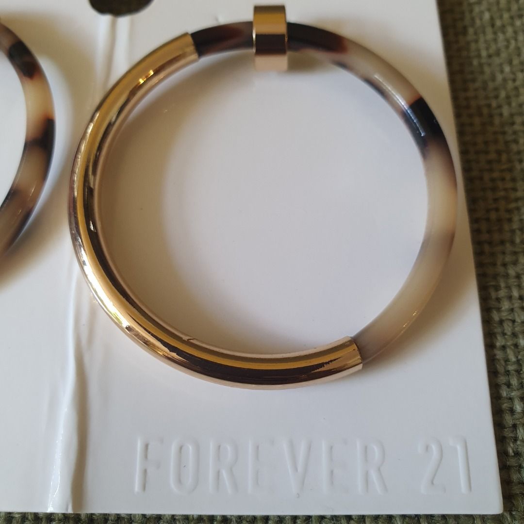 Forever 21 Gold and Brown Tortoise Shell Like Earrings (Category: Earrings) located in Caloocan City. Submitted by mma_222 (Listing ID 1469190268, Image 3). Description: - Brand: Forever 21 - Design: Large circular hoops with gold-tone hardware and brown tortoise shell pattern - Size: Approximately 2 inches across - Condition: Brand new, never worn, on original cardboard store backing.