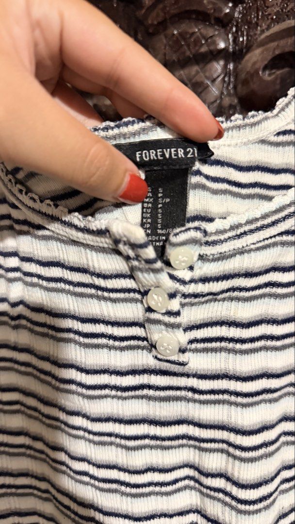 Forever 21 Striped Ribbed Tank Top Size S (Category: Sleeveless) located in Las Pinas. Submitted by aliah2703 (Listing ID 1469173563, Image 3). Description: - Brand: Forever 21 - Size: S - Color: White with dark blue stripes - Details: Scoop neckline, button-up front placket, lettuce trim on straps and collar - Material: Lightweight and comfortable - Style: Versatile basic piece, perfect to match with high-waisted denim or skirts for everyday wea