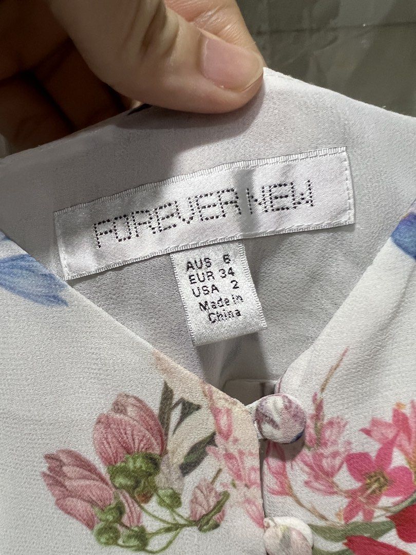Forever New Floral Cami Top (Category: Sleeveless) located in Taguig. Submitted by strutstella (Listing ID 1469320817, Image 2). Description: - Brand: Forever New - Design: White with all-over floral print, button-front, and V-neck - Straps: Thin and adjustable - Fabric: Lightweight and breathable - Size: AUS 6, EUR 34, USA 2 (Equivalent to UK 6 / US 2 / Extra Small) - Condition: Great for warm weather layering or wearing on its own Up to 34 bust