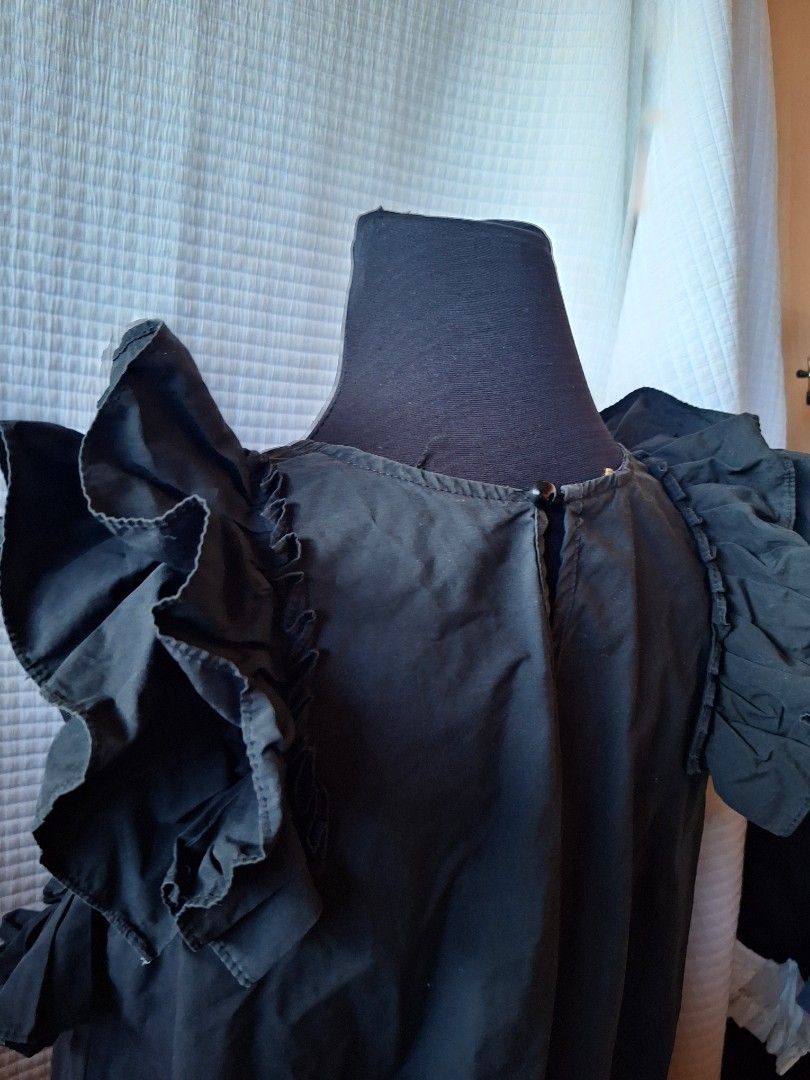 Frill Cute Black ruffled sleeveless top with back keyhole button (Category: Sleeveless) located in Balamban. Submitted by ubethan (Listing ID 1469232698, Image 3). Description: - Color: Black - Style: Sleeveless top with dramatic ruffled shoulders and asymmetric hem - Neckline: Scoop neck with back keyhole and button closure - Fabric: Lightweight with great movement - Versatility: Perfect for both casual daytime looks and dressed-up evening outfi