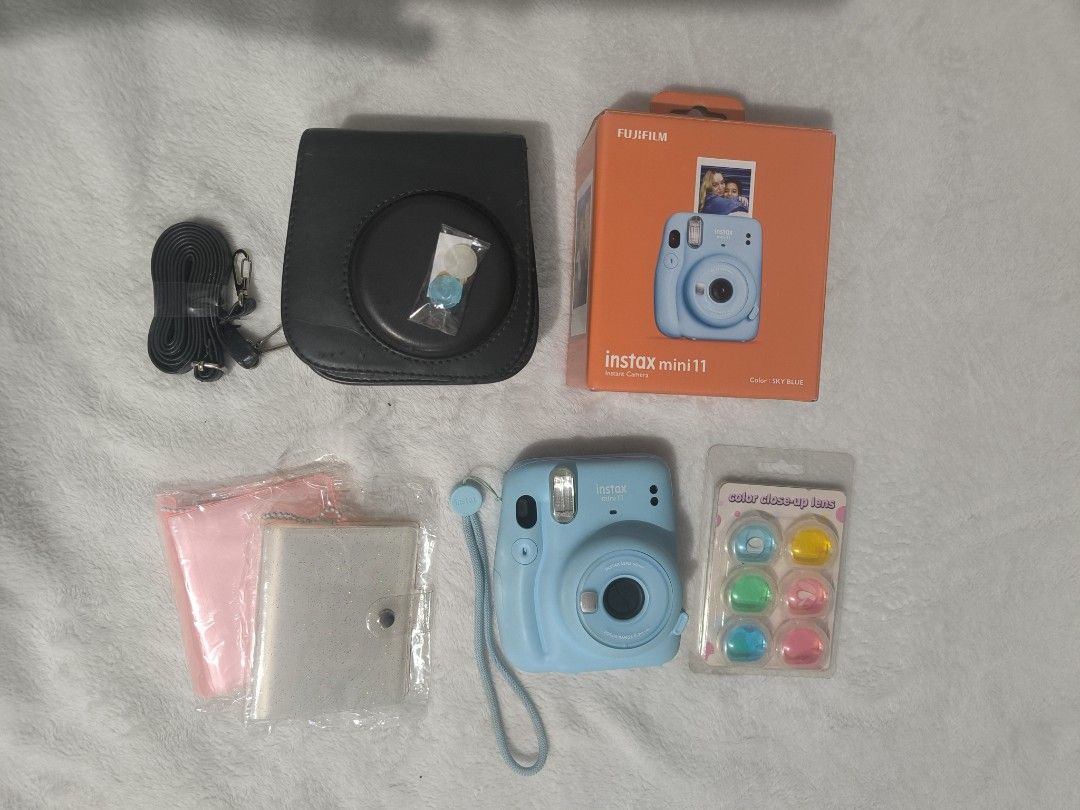 Fujifilm Instax Mini 11 (Category: Cameras) located in Manila. Submitted by krueyzei (Listing ID 1469195799, Image 1). Description: Fujifilm Instax Mini 11 PHP 3,200 (Slightly Negotiable) Bundle includes: - Fujifilm Instax Mini 11 camera - Original wrist strap - Original Box - 2 decorative jewel button caps - Sling bag with strap - Colour lenses - 2 photo albums *NO BATTERIES INCLUDED.