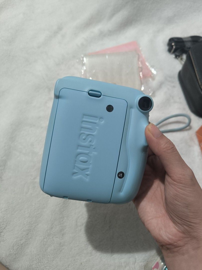 Fujifilm Instax Mini 11 (Category: Cameras) located in Manila. Submitted by krueyzei (Listing ID 1469195799, Image 3). Description: Fujifilm Instax Mini 11 PHP 3,200 (Slightly Negotiable) Bundle includes: - Fujifilm Instax Mini 11 camera - Original wrist strap - Original Box - 2 decorative jewel button caps - Sling bag with strap - Colour lenses - 2 photo albums *NO BATTERIES INCLUDED.