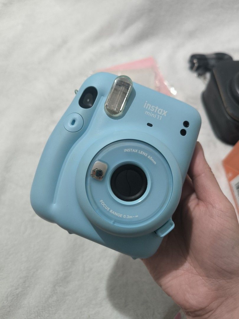 Fujifilm Instax Mini 11 (Category: Cameras) located in Manila. Submitted by krueyzei (Listing ID 1469195799, Image 2). Description: Fujifilm Instax Mini 11 PHP 3,200 (Slightly Negotiable) Bundle includes: - Fujifilm Instax Mini 11 camera - Original wrist strap - Original Box - 2 decorative jewel button caps - Sling bag with strap - Colour lenses - 2 photo albums *NO BATTERIES INCLUDED.