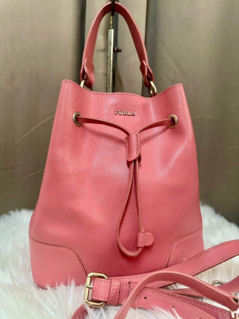Furla Pink Leather Bucket Bag (Category: Luxury Bags & Wallets) located in Santiago. Submitted by evrythngulove (Listing ID 1469334774, Image 3). Description: pink Furla leather bucket bag with gold-tone hardware. Features a drawstring closure, top handle, adjustable shoulder strap, and unlined interior. Clean condition inside and out. Great everyday size!.