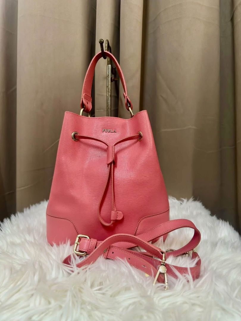 Furla Pink Leather Bucket Bag (Category: Luxury Bags & Wallets) located in Santiago. Submitted by evrythngulove (Listing ID 1469334774, Image 2). Description: pink Furla leather bucket bag with gold-tone hardware. Features a drawstring closure, top handle, adjustable shoulder strap, and unlined interior. Clean condition inside and out. Great everyday size!.