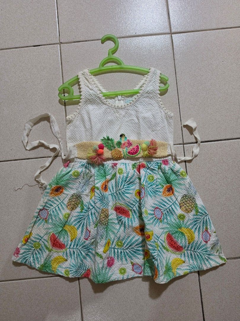 Gingersnaps Tropical Fruit Print Dress Size 6 (Category: Babies & Kids Fashion) located in Manila. Submitted by dshopco (Listing ID 1469307663, Image 1). Description: - Brand: Gingersnaps - Size: 6 - Design: White textured sleeveless top with pom pom neckline trim & colorful tropical fruit skirt (watermelon, banana, pineapple, avocado) - Details: Attached woven waist belt with yarn pom poms and fruit embroidery - Closure: Back zip - Condition: Ex