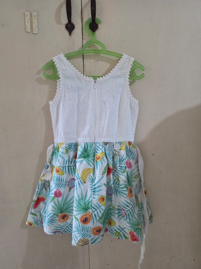 Gingersnaps Tropical Fruit Print Dress Size 6 (Category: Babies & Kids Fashion) located in Manila. Submitted by dshopco (Listing ID 1469307663, Image 2). Description: - Brand: Gingersnaps - Size: 6 - Design: White textured sleeveless top with pom pom neckline trim & colorful tropical fruit skirt (watermelon, banana, pineapple, avocado) - Details: Attached woven waist belt with yarn pom poms and fruit embroidery - Closure: Back zip - Condition: Ex