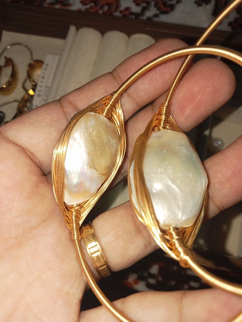 Gold wire wrapped baroque pearl open bangles (Category: Bracelets) located in Davao. Submitted by kimpoycaye62726 (Listing ID 1469328495, Image 3). Description: - Set of 2 gold tone wire-wrapped bangles ₱500 each - Large baroque pearl centerpieces with beautifully irregular shapes - Extra small pearls detailing the ends of the bands - Flexible open cuff design for easy slip-on wear - Eye-catching statement jewelry that sparkles in the light.