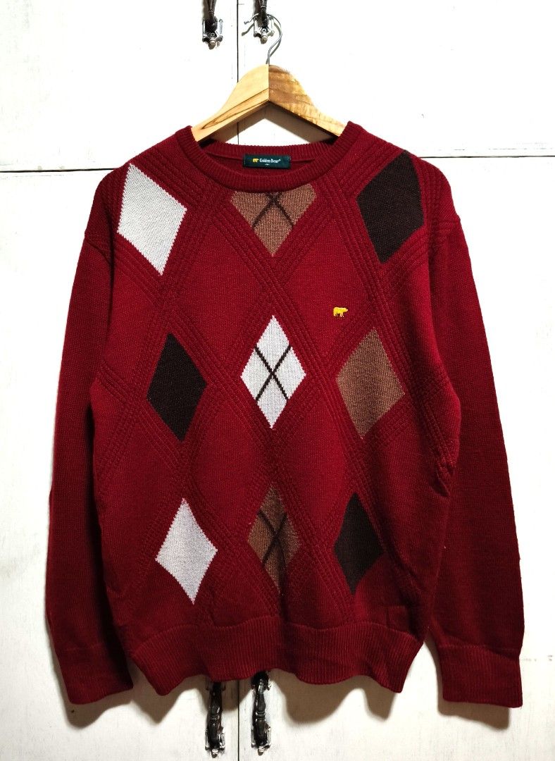 Golden Bear Argyle Knit Sweater Red (Category: Longsleeves) located in Makati City. Submitted by thriftersmakati (Listing ID 1469364158, Image 1). Description: - Brand: Golden Bear - Color: Dark red with white, brown, and dark brown argyle pattern - Details: Small embroidered gold bear logo on the chest - Fit: Relaxed fit with ribbed crew neck, cuffs, and hem - Material: Warm acrylic/wool blend fabric - Condition: Excellent pre-loved condition.