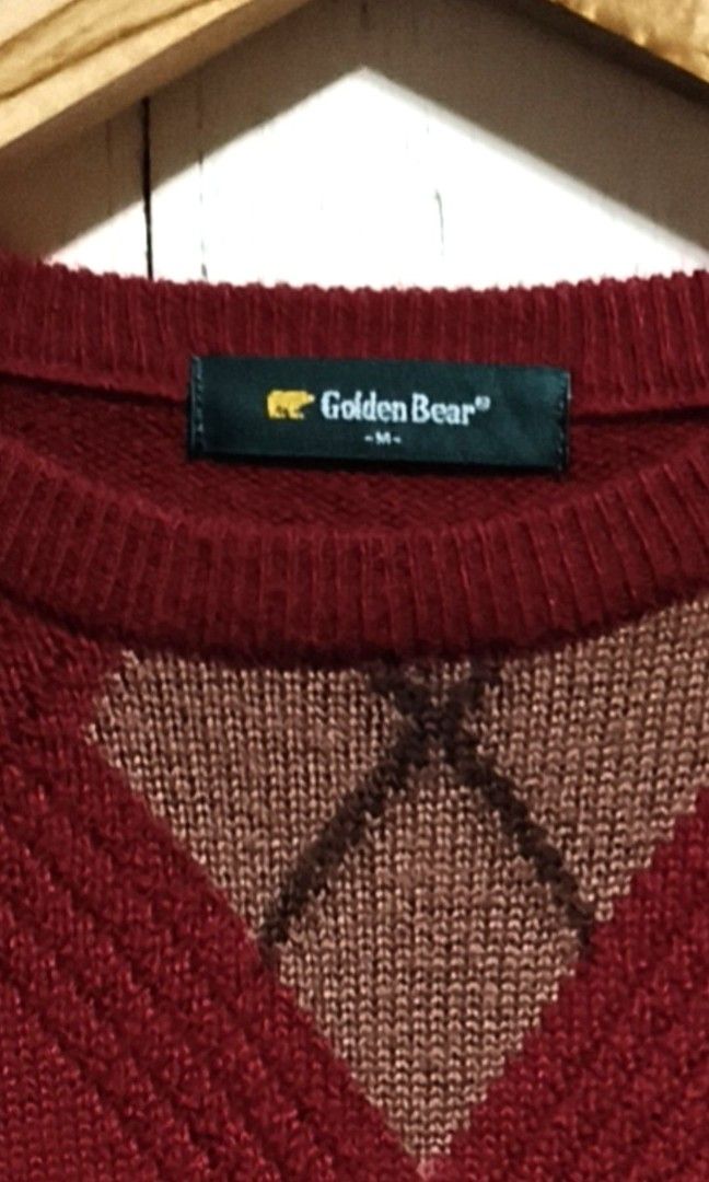 Golden Bear Argyle Knit Sweater Red (Category: Longsleeves) located in Makati City. Submitted by thriftersmakati (Listing ID 1469364158, Image 2). Description: - Brand: Golden Bear - Color: Dark red with white, brown, and dark brown argyle pattern - Details: Small embroidered gold bear logo on the chest - Fit: Relaxed fit with ribbed crew neck, cuffs, and hem - Material: Warm acrylic/wool blend fabric - Condition: Excellent pre-loved condition.