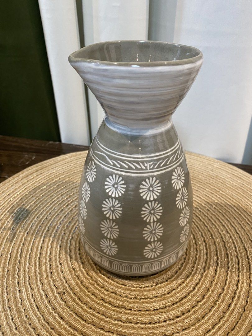 Gray ceramic vase with white floral pattern and spout (Category: Vases & Decorative Bowls) located in San Pedro. Submitted by jingay81 (Listing ID 1469372082, Image 1). Description: - Material: Sturdy gray ceramic - Design: Vertical white floral pattern with a flared top rim and pouring spout - Dimensions: Approximately 17 cm tall - Use: Perfect as a tabletop decor piece or a small accent vase - Condition: Excellent, ready for display.