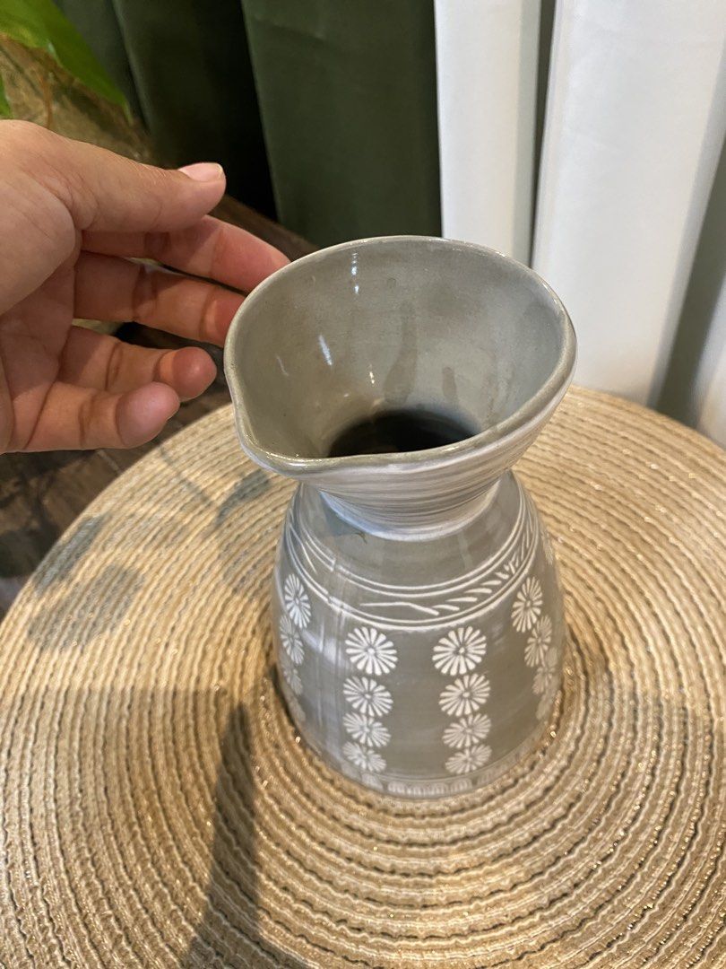 Gray ceramic vase with white floral pattern and spout (Category: Vases & Decorative Bowls) located in San Pedro. Submitted by jingay81 (Listing ID 1469372082, Image 2). Description: - Material: Sturdy gray ceramic - Design: Vertical white floral pattern with a flared top rim and pouring spout - Dimensions: Approximately 17 cm tall - Use: Perfect as a tabletop decor piece or a small accent vase - Condition: Excellent, ready for display.