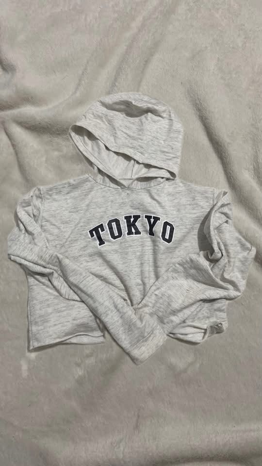 Grey Tokyo Crop Hoodie Long Sleeve Pullover (Category: Coats, Jackets and Outerwear) located in Manila. Submitted by nobleowl-8fff (Listing ID 1469286709, Image 1). Description: - Style: Grey cropped hoodie with 'TOKYO' printed across the chest - Fit: Relaxed fit with long sleeves and a trendy raw hem finish - Material: Lightweight, comfortable fabric in a heather grey colorway - Versatility: Perfect casual piece for daily wear, running errands, 