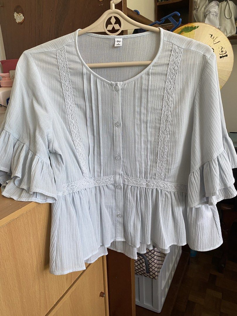 GU Light Blue Button-Up Blouse Size S (Category: Blouses) located in Manila. Submitted by freestone_f18729 (Listing ID 1469183861, Image 1). Description: - Brand: GU - Size: S - Color: Light Blue - Material: 61% Cotton, 39% Polyester (Cotton lace trim) - Design: Button-up front, pleated panels with delicate lace inserts, layered ruffle sleeves, and a flared peplum hem - Origin: Made in Cambodia - Condition: Excellent / Ready to wear.