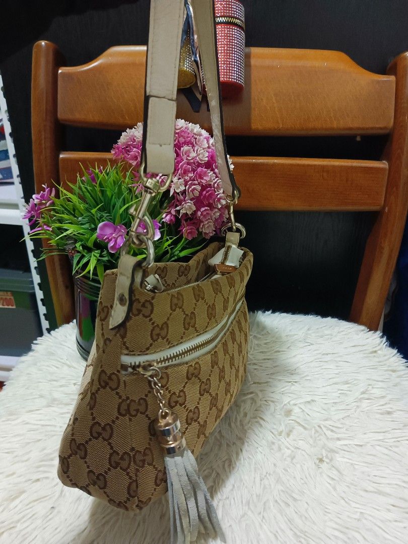 Gucci GG Canvas Shoulder Bag (Category: Luxury Bags & Wallets) located in Digos. Submitted by chihanu (Listing ID 1469194577, Image 3). Description: - Gucci shoulder bag in classic beige and brown monogram canvas - Stylish white leather trim and matching strap with gold-tone hardware - Playful grey tassel charm on the front zip pocket - Clean interior with a well-structured shape - Great everyday size to fit all your daily essentials.
