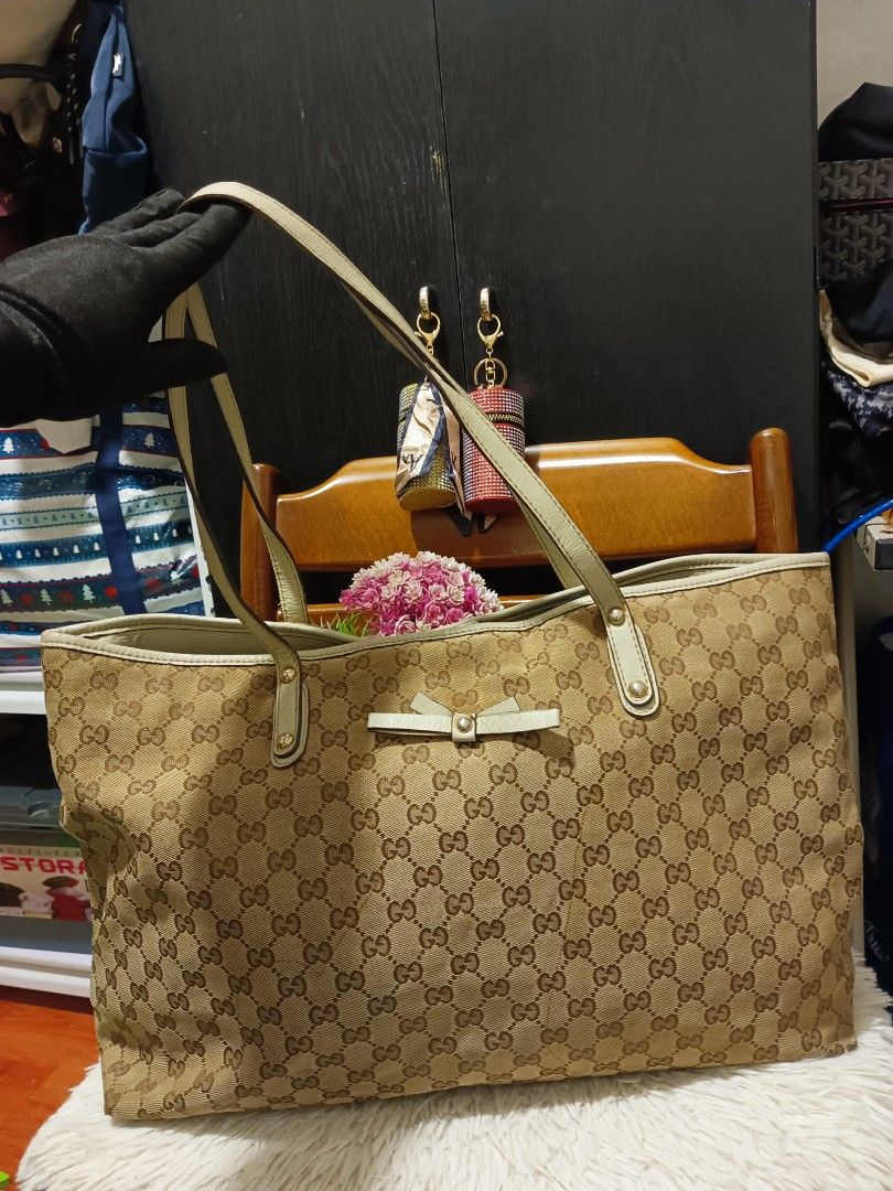 Gucci GG Canvas Tote Bag with Bow (Category: Tote Bags) located in Digos. Submitted by chihanu (Listing ID 1469201404, Image 1). Description: - Gucci tote bag - Beige GG canvas fabric with light-colored leather straps and trim - Charming small decorative leather bow on the front center - Secure magnetic snap closure at the top - Spacious interior to fit all your daily essentials - Condition note: Dual shoulder handles show some visible edge wear 