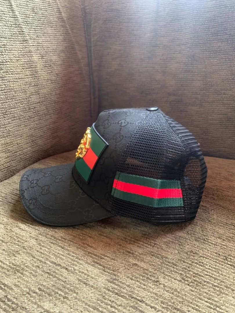 Gucci GG Monogram Mesh Trucker Hat (Category: Caps & Hats) located in San Juan City. Submitted by findmorelux (Listing ID 1469226271, Image 2). Description: - designer trucker hat - Classic black mesh design with GG monogram pattern - Front patch featuring the signature red and green Web stripe and gold bamboo double G logo - Breathable mesh back panels for everyday comfort - Adjustable snapback closure for a custom fit - Brown leather Gucci logo