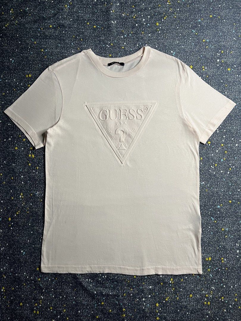Guess Embossed Logo Crew Neck T-Shirt Pink Medium (Category: Shirts) located in Manila. Submitted by lj_thrifter (Listing ID 1469168739, Image 1). Description: - Brand: Guess - Color: Pale Pink - Size: M - Color rate 9.5/10 - No issue - Material: 100% Cotton (Made in Korea) - Fit: Standard fit - Design: Classic crew neck with tonal embossed triangular logo on chest - Style: Clean design, ideal for everyday casual wear.