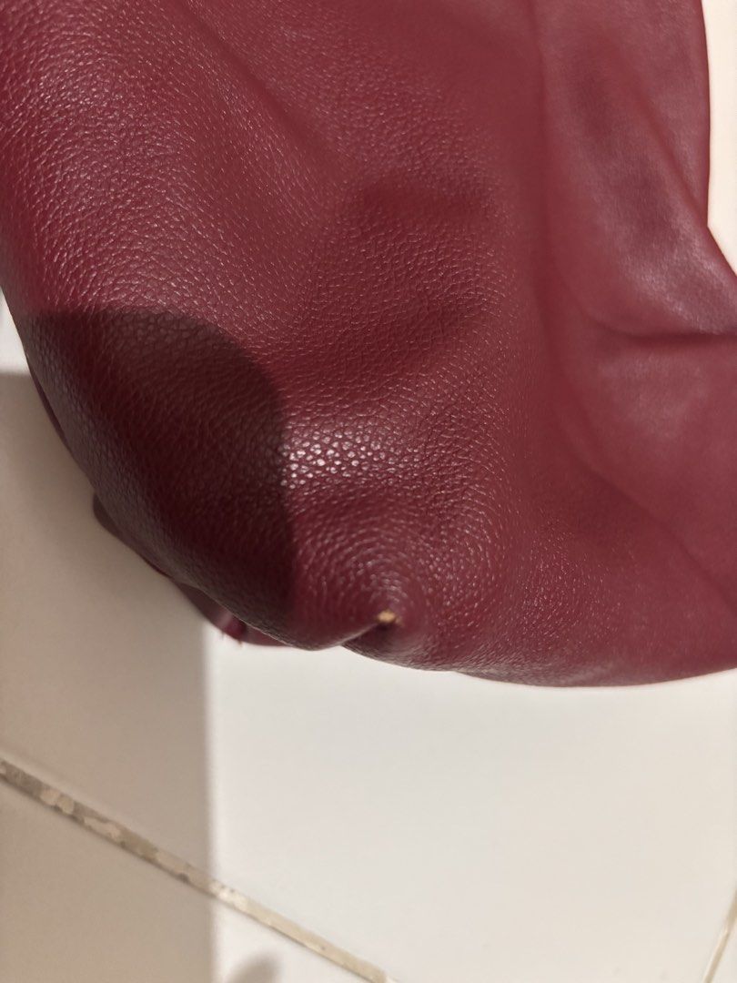 GVN Maroon Red Leather Shoulder Bag (Category: Shoulder Bags) located in Pasay City. Submitted by _mcrnj (Listing ID 1469336432, Image 2). Description: - Color & Material: Deep maroon red in textured faux leather - Design: Soft, slouchy shape with a wide strap and chic gold hardware ring detail - Interior: Clean white canvas lining - Closure: Secure top zip closure - Condition: Good pre-loved condition with a small scuff mark on one bottom corner