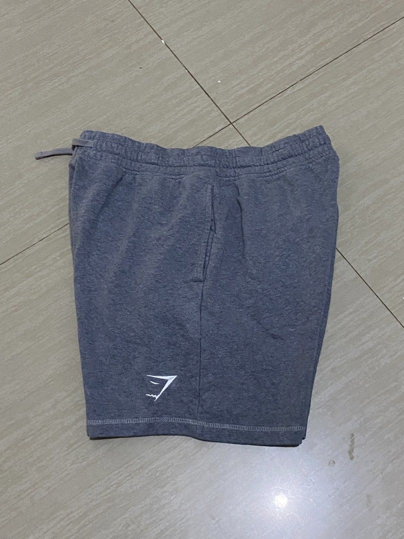 Gymshark Grey Sweatshorts Size L (Category: Shorts) located in Manila. Submitted by monterdeal90433 (Listing ID 1469315034, Image 3). Description: - Brand: Gymshark - Item: Sweatshorts - Color: Dark Grey Marl - Size: Large - Material: Soft fleece interior lining - Features: Elastic waistband with adjustable drawstring, two side pockets, and one back pocket - Branding: Small embroidered white Gymshark logo near the left hem - Origin: Made in Bangl