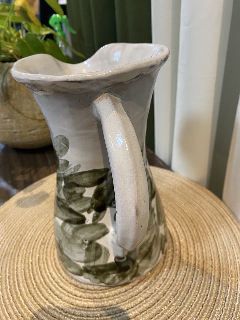 Handmade Ceramic Pitcher White Green Abstract Brush Strokes (Category: Vases & Decorative Bowls) located in San Pedro. Submitted by jingay81 (Listing ID 1469370227, Image 2). Description: - Handmade ceramic pitcher with unique earthy look - White glaze base with green abstract brush stroke pattern - Equipped with a sturdy side handle and flared pouring spout - Natural glaze variations make each piece one-of-a-kind.
