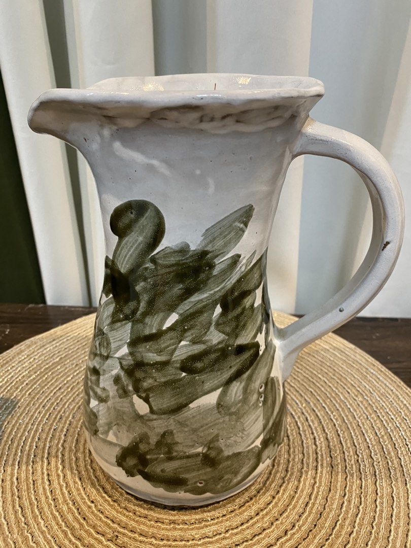 Handmade Ceramic Pitcher White Green Abstract Brush Strokes (Category: Vases & Decorative Bowls) located in San Pedro. Submitted by jingay81 (Listing ID 1469370227, Image 1). Description: - Handmade ceramic pitcher with unique earthy look - White glaze base with green abstract brush stroke pattern - Equipped with a sturdy side handle and flared pouring spout - Natural glaze variations make each piece one-of-a-kind.