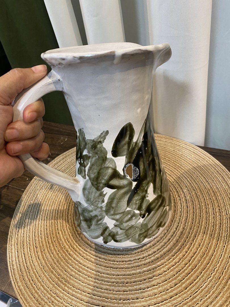 Handmade Ceramic Pitcher White Green Abstract Brush Strokes (Category: Vases & Decorative Bowls) located in San Pedro. Submitted by jingay81 (Listing ID 1469370227, Image 3). Description: - Handmade ceramic pitcher with unique earthy look - White glaze base with green abstract brush stroke pattern - Equipped with a sturdy side handle and flared pouring spout - Natural glaze variations make each piece one-of-a-kind.