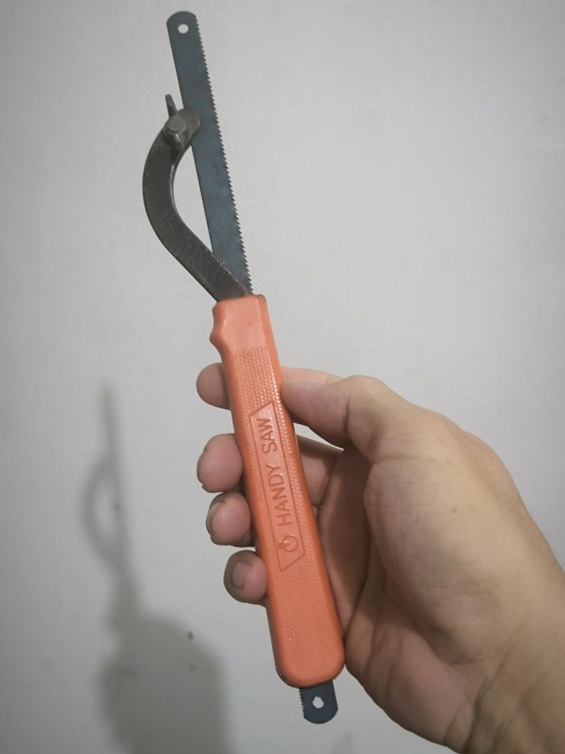 Handy Saw Compact Hand Saw with Orange Handle (Category: Home Improvement Tools & Accessories) located in Angeles City. Submitted by yellowbrickstore (Listing ID 1469183083, Image 1). Description: - Compact hand saw with a comfortable orange plastic handle - Durable blue metal blade with fine teeth for cutting various materials - Features a metal curved guard near the base for safety and control - Ideal for small DIY projects, repairs around the 