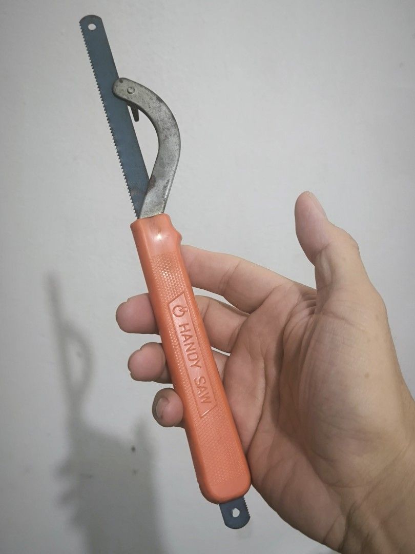 Handy Saw Compact Hand Saw with Orange Handle (Category: Home Improvement Tools & Accessories) located in Angeles City. Submitted by yellowbrickstore (Listing ID 1469183083, Image 2). Description: - Compact hand saw with a comfortable orange plastic handle - Durable blue metal blade with fine teeth for cutting various materials - Features a metal curved guard near the base for safety and control - Ideal for small DIY projects, repairs around the 