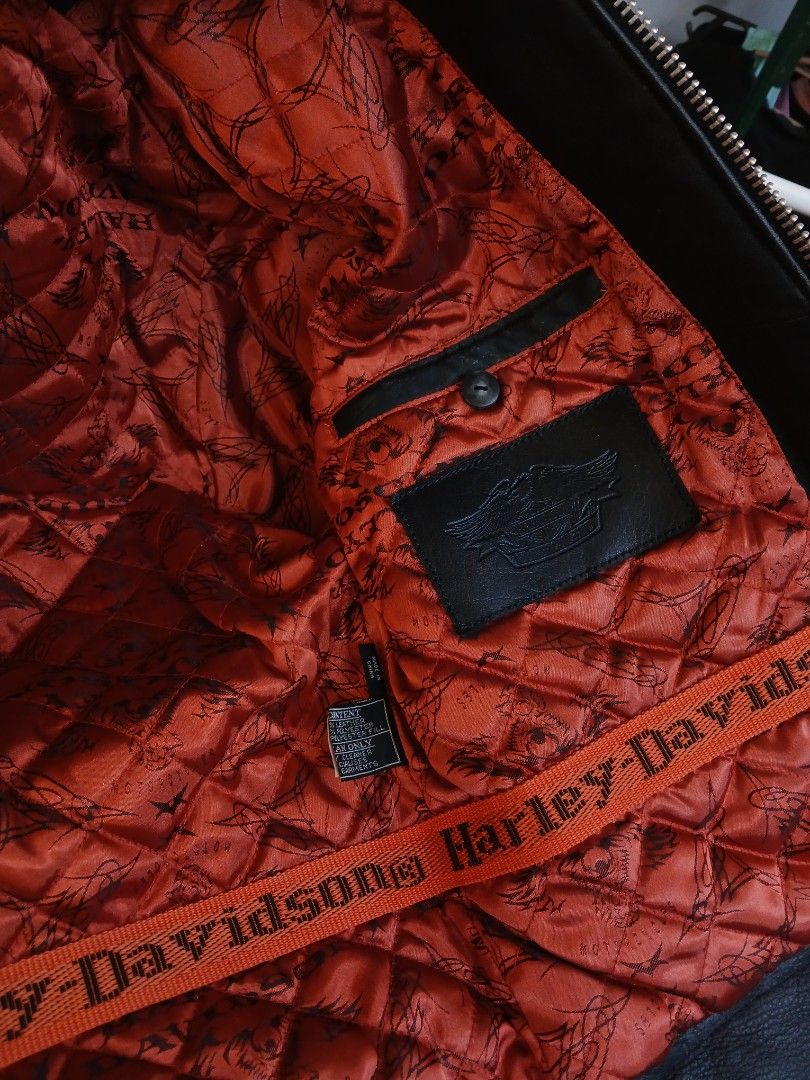 Harley-Davidson Black Leather Motorcycle Jacket (Category: Coats, Jackets and Outerwear) located in Manila. Submitted by itsmebeiii18 (Listing ID 1469183543, Image 2). Description: - Brand: Harley-Davidson - Material: Genuine black leather - Lining: Bright red quilted lining with unique script prints and branded orange strap detail - Features: Full zip closure, classic collar, and practical side pockets - Style: Solid, heavy-duty biker constructi