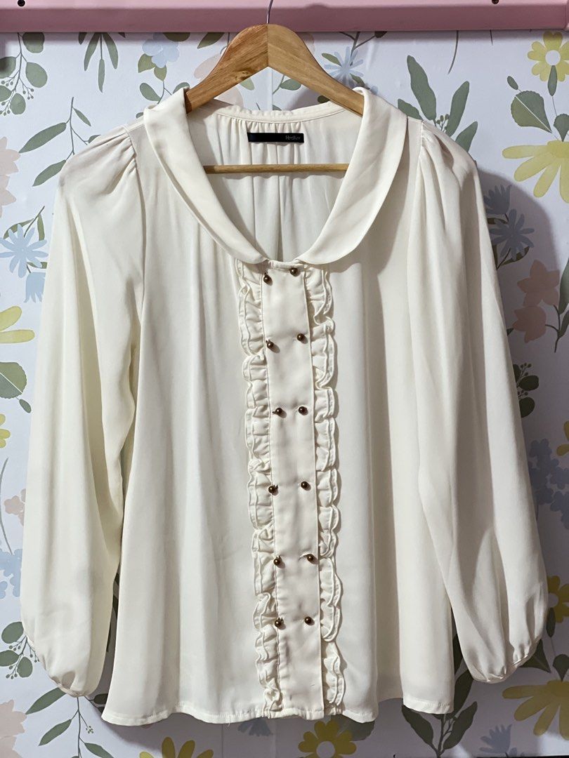 Heather White Ruffle Long Sleeve Blouse (Category: Longsleeves) located in Pasig City. Submitted by morilove (Listing ID 1469163085, Image 1). Description: - Brand: Heather - Color: White - Size: Free Size (F) - Material: 100% Polyester (lightweight with a smooth finish) - Features: Ruffled front placket, gold-tone dome buttons, classic collar - Condition: Excellent / Well-maintained - Style: Ideal for workwear, office attire, or smart casual out