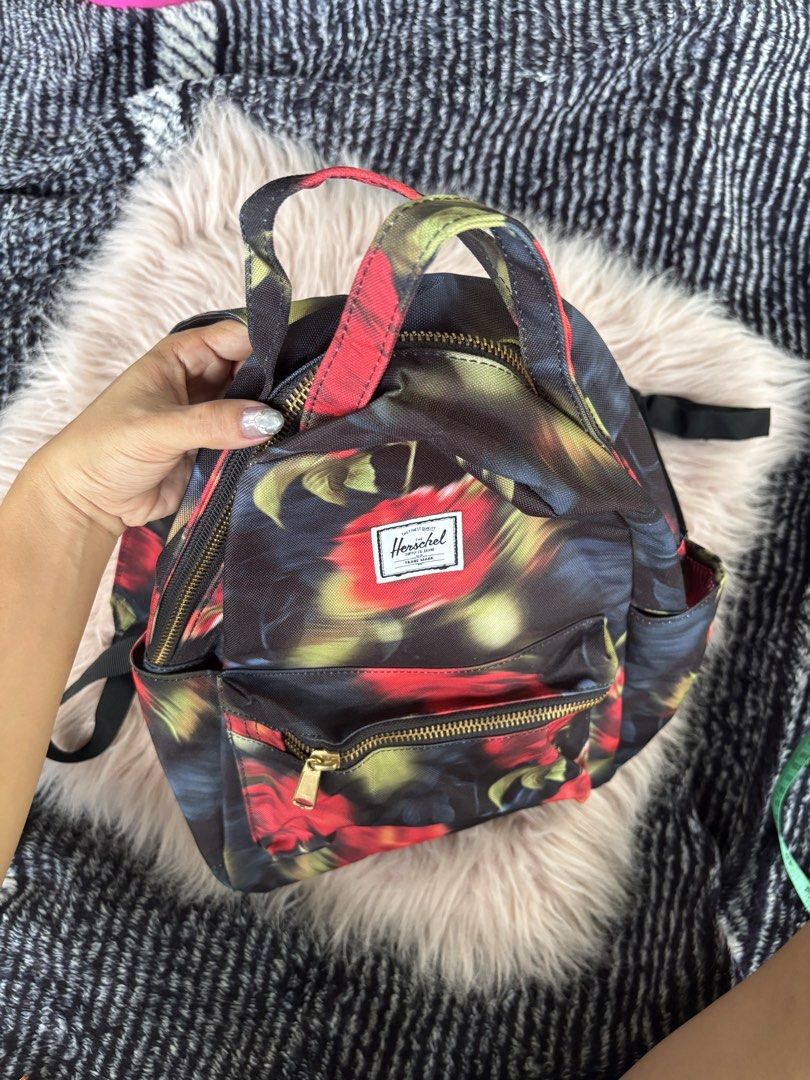 Herschel Supply Co. Floral Mini Backpack (Category: Backpacks) located in Digos. Submitted by kathydiane76376 (Listing ID 1469318952, Image 2). Description: - Brand: Herschel - Design: Moody red and black floral print with chic gold hardware - Storage: Main double-zipper closure and convenient front zip pocket - Comfort: Adjustable shoulder straps and sturdy top grab handle - Condition: Clean canvas fabric inside and out - Usage: Great everyday s