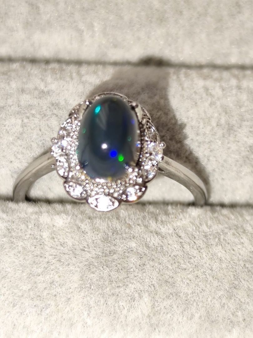 HIGH QUALITY 1 carat Natural Black Opal Simple Oval Ring (Category: Rings) located in Mandaluyong City. Submitted by allaboutgemsandco (Listing ID 1469227208, Image 3). Description: HIGH QUALITY 1 carat Natural Black Opal Simple Oval Ring Stone Size: 8.2mmx6.2mm Ring Size: Adjustable Price: Php 600 add shipping fee for order less than 1k REASON FOR SALE: Clearing out my collection. This stunning piece is a Black Opal and Diamond Halo Ring, crafte