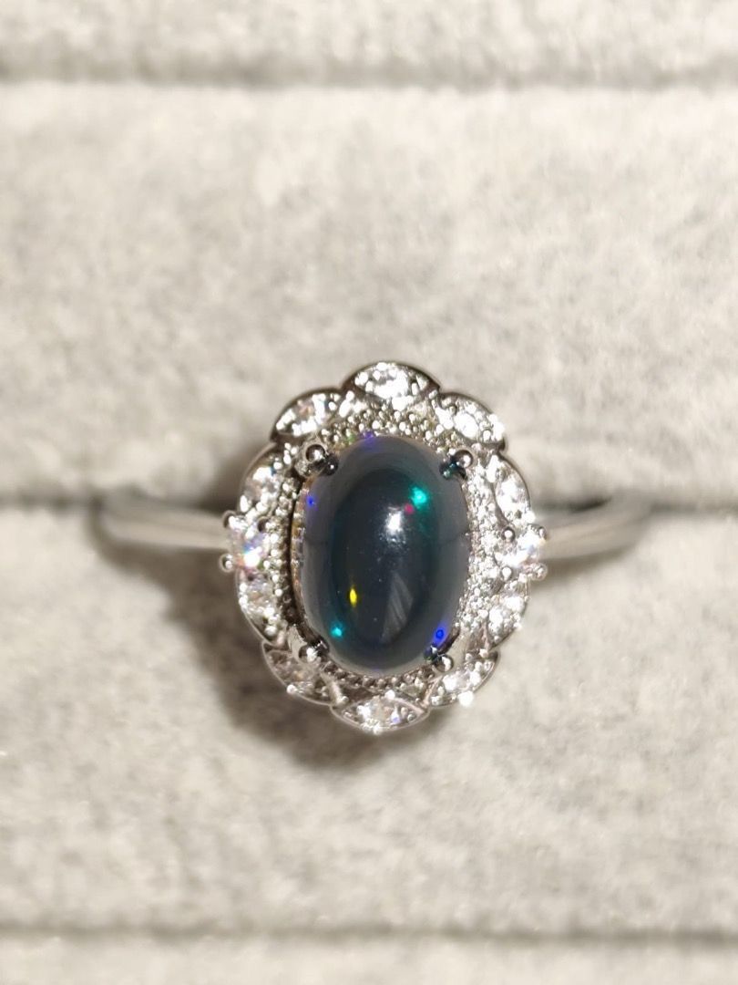 HIGH QUALITY 1 carat Natural Black Opal Simple Oval Ring (Category: Rings) located in Mandaluyong City. Submitted by allaboutgemsandco (Listing ID 1469227208, Image 2). Description: HIGH QUALITY 1 carat Natural Black Opal Simple Oval Ring Stone Size: 8.2mmx6.2mm Ring Size: Adjustable Price: Php 600 add shipping fee for order less than 1k REASON FOR SALE: Clearing out my collection. This stunning piece is a Black Opal and Diamond Halo Ring, crafte