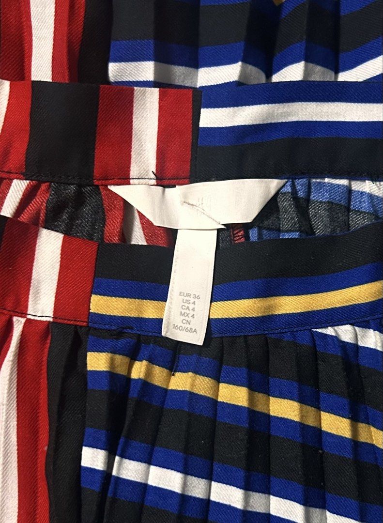 H&M (Category: Skirts) located in Davao. Submitted by sart0ria85 (Listing ID 1469297326, Image 3). Description: Contrasting split panels with vertical stripes (red, black, white) on one side and horizontal stripes (blue, black, white, yellow) on the other. 100% POLYESTER MADE IN CHINA 🇨🇳 SMALL. Size 4 EXCELLENT CONDITION (92/100) - Condition: Excellent / Pre-loved (ready to wear).