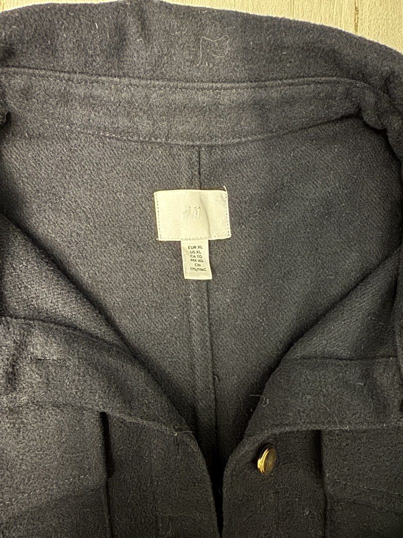 H&M Black Oversized Button-Up Jacket (Category: Coats, Jackets and Outerwear) located in Taguig. Submitted by sqaumejada (Listing ID 1469163442, Image 2). Description: - Brand: H&M - Color: Navy Blue - Size: XL - Details: Gold-tone hardware buttons on front, cuffs, and dual chest pockets - Style: Classic collar with structured back seams - Material: Thick, fleece-like textured fabric (warm for cooler days) - Condition: Clean and well maintained.