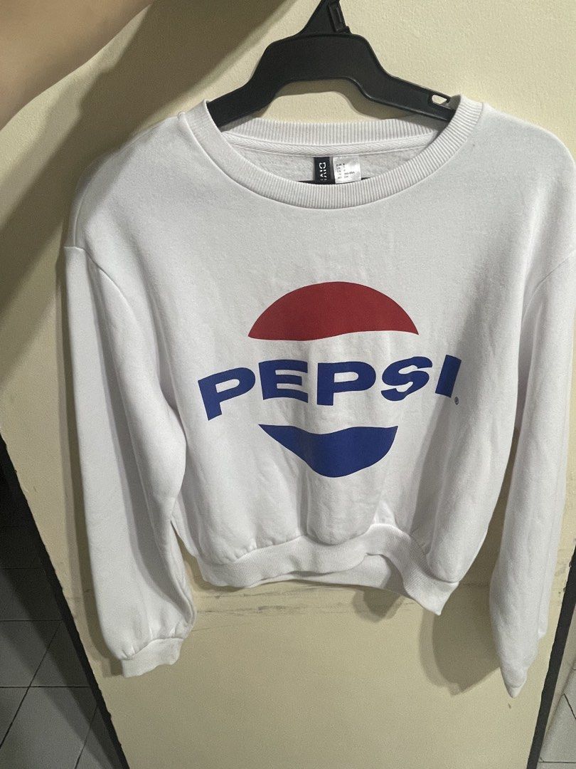 H&M Pepsi White Cropped Sweatshirt (Category: Coats, Jackets and Outerwear) located in Manila. Submitted by tineferna08917 (Listing ID 1469200345, Image 1). Description: - Authentic Pepsi logo printed across the chest - Size: Small - Color: Classic White - Style: Cropped sweatshirt with crewneck and long sleeves - Details: Ribbed cuffs, collar, and hem with slightly gathered shoulders - Interior: Soft and comfortable fleece material - Condition: 