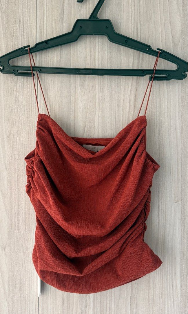 H&M Rust Red Ruched Cami Top (Category: Sleeveless) located in Quezon City. Submitted by oliviablanche (Listing ID 1469239869, Image 1). Description: - Brand: H&M - Size: S - Color: Rust Red - Neckline: Cowl front with thin spaghetti straps - Details: Textured crinkle fabric with heavy side ruching and straight back cut - Styling: Versatile piece, easy to dress up with trousers or keep casual with denim - Condition: Brand new - Mode of Payment: G