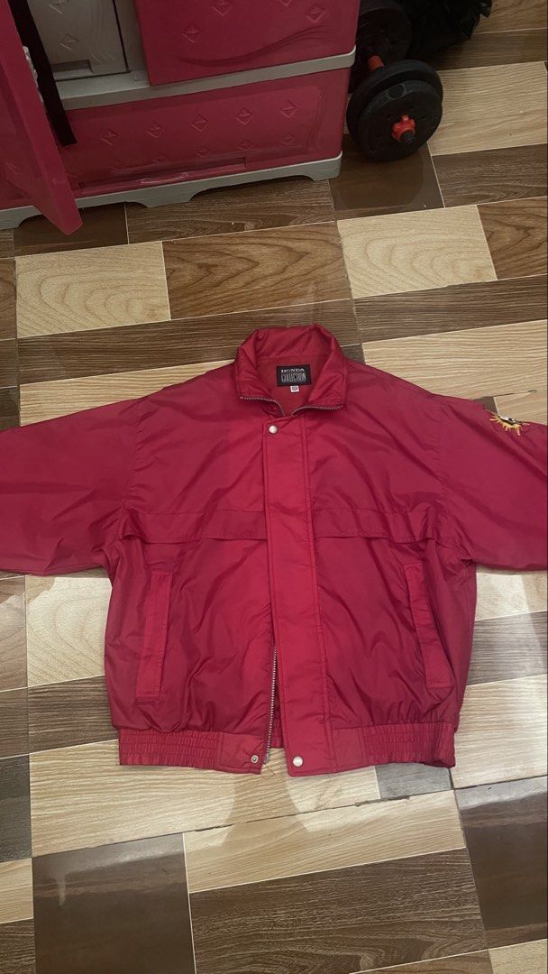 Honda Red Vintage Jacket with Embroidered Sleeve Patch (Category: Coats, Jackets and Outerwear) located in Floridablanca. Submitted by izekiar (Listing ID 1469225600, Image 1). Description: - Color: Bright red - Closure: Full front zipper with snap button placket - Collar: High collar design for wind protection - Details: Unique embroidered circular sun and hand graphic patch on the sleeve - Fit: Ribbed waistband at the bottom - Material: Thick, 