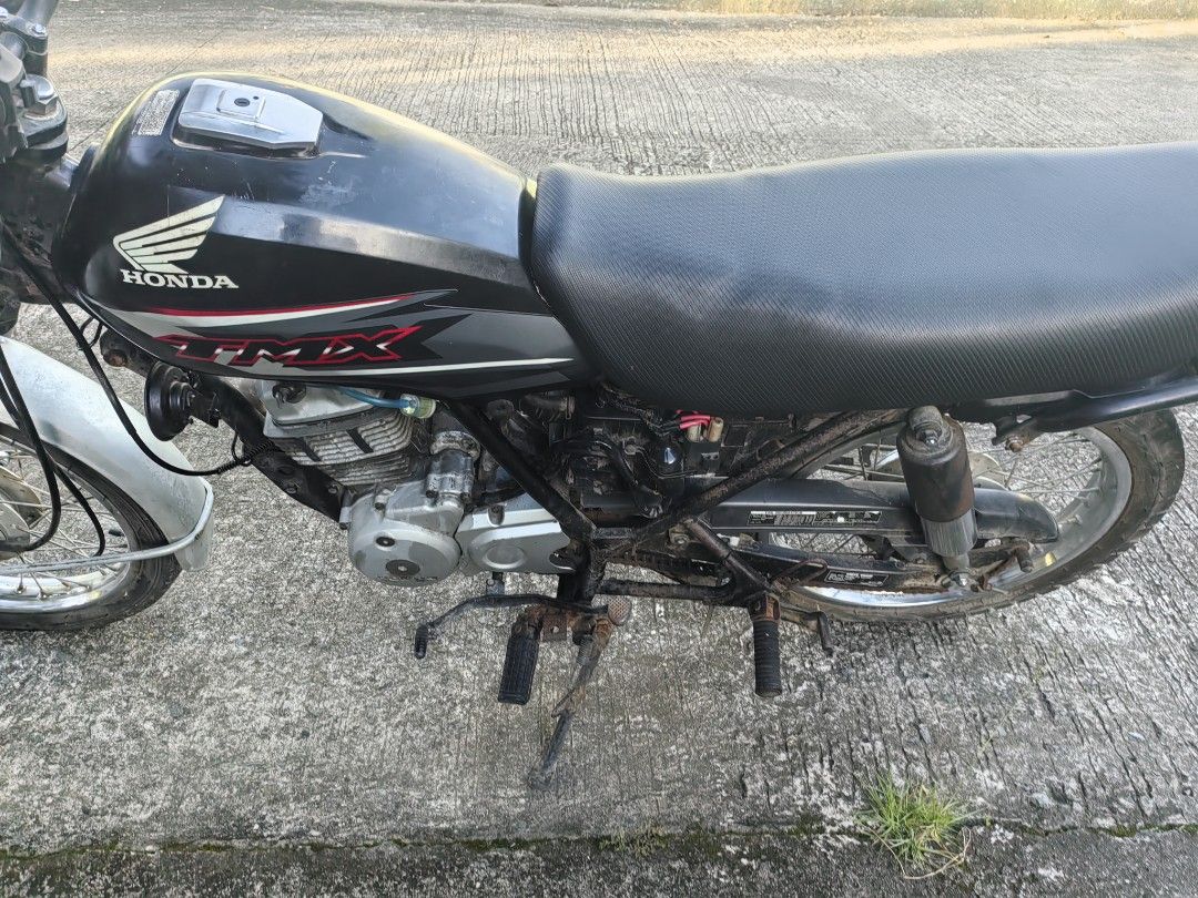 Honda TMX motorcycle (Category: Motorbikes for Sale) located in Silang. Submitted by jamessseller (Listing ID 1469247546, Image 1). Description: Black Honda TMX motorcycle. Manual transmission with standard handlebars and round headlight. Rear cargo rack included, plus registered license plate mounted at the back. Spoke wheels on both front and rear. Frame and exhaust show some rust spots from use. Engine block intact with kick starter..