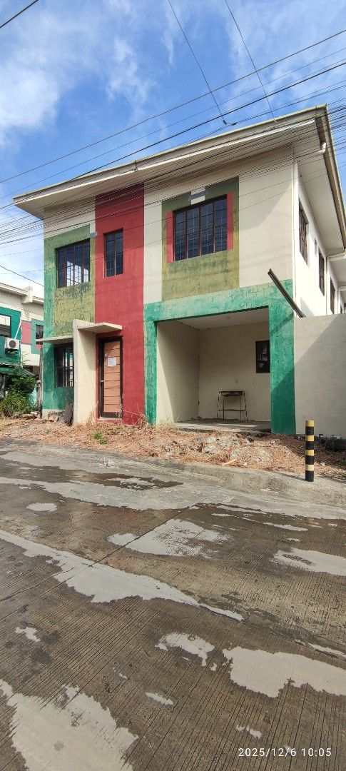 House and lot for assume (Category: House & Lot) located in Dasmarinas. Submitted by jdelacruz0728 (Listing ID 1469228019, Image 3). Description: House and lot for assume Golden Horizon Trece Martires Cavite - Multi-storey townhouse with modern red, green, and cream exterior - Ready for occupancy with clean, well-maintained lines - Ground floor includes a designated car garage space - Convenient concrete driveway alongside the structure - Bright 