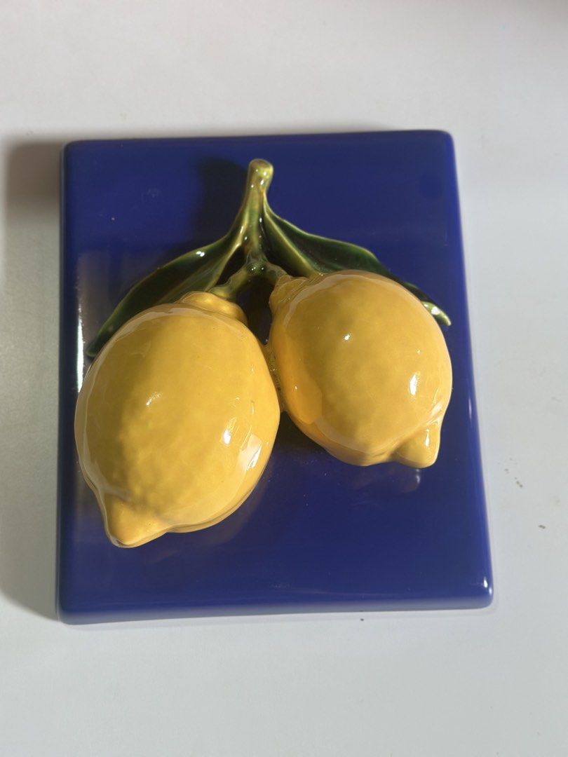 Italian ceramic wall tile featuring two yellow lemons (Category: Other Home Decor) located in Davao. Submitted by favoritepreloved (Listing ID 1469205240, Image 1). Description: 💜 with green leaves in relief set against a deep blue background 💜 16cm x 16cm 💜 Made in Italy 💜 Flaws: meron small chip sa back part pero di kita sa harap.