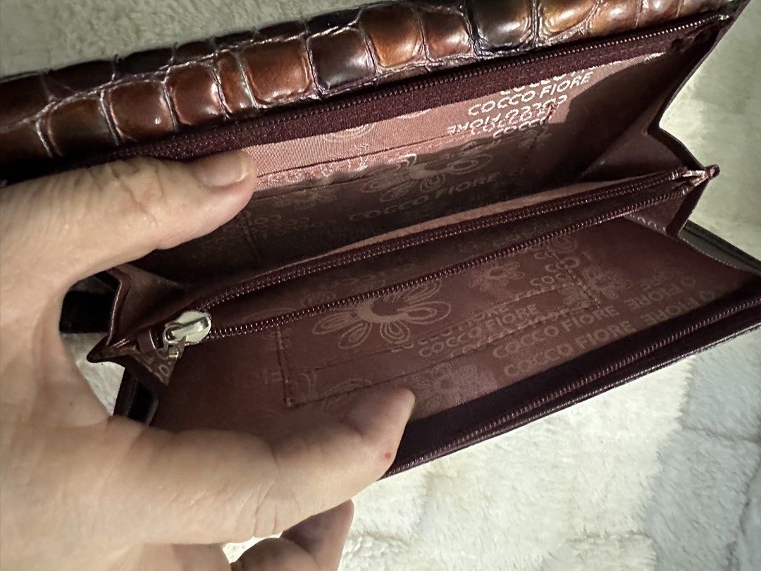 Italy Croc Embossed Long Wallet! (Category: Wallets & Card holders) located in Santa Rosa. Submitted by esplanamur03635 (Listing ID 1469230611, Image 3). Description: Authentic Italy Cocco Fiore bifold long wallet in saffiano leather glossy brown croc-embossed leather, silver hardware soft leather clean pink logo-print interior multiple card slots, slip pockets, and a middle zip coin pocket YKK zipper No flaws very excellent condition Good as new