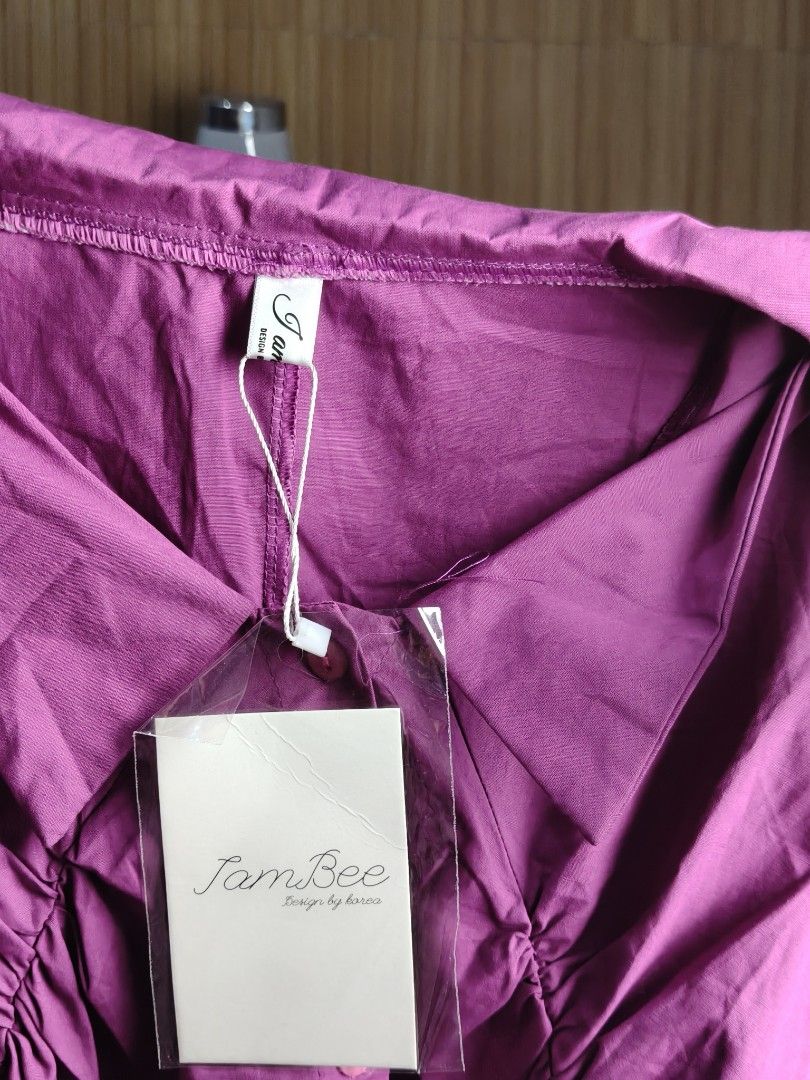 JamBee Purple Puffed Sleeve Button Dress (Category: Dresses) located in Taguig. Submitted by ashie_clothing (Listing ID 1469204973, Image 3). Description: - Brand: JamBee - Style: Korean design, mini length flare cut - Details: Short puffed sleeves with ruffled cuffs, classic collar, front button closure, and gathered pleat bodice - Condition: Brand new with original brand tag still attached - Color: Purple.