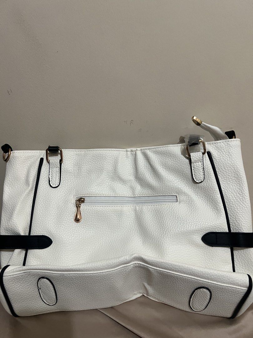 JARA White Soft Leather Handbag (Category: Tote Bags) located in Quezon City. Submitted by heyyybabe (Listing ID 1469289924, Image 2). Description: - Color: White faux leather with contrast black trim and straps - Hardware: Premium gold-tone hardware, including front brand plaque and decorative charms - Storage: Main compartment for daily essentials + convenient exterior back zipper pocket - Design: Elegant structured shape, perfect for work, sch