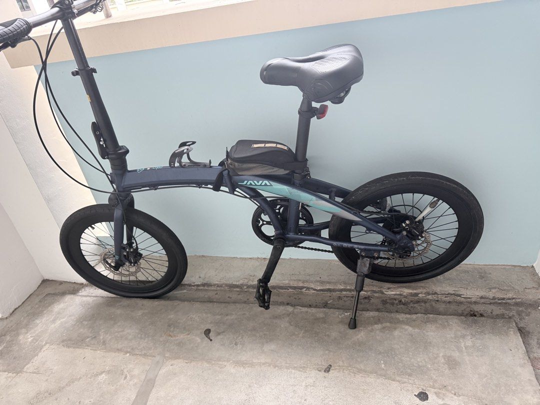 JAVA Folding Bicycle Blue (Category: Bicycles) located in Singapore. Submitted by jayankaji (Listing ID 1469187243, Image 2). Description: - Brand/Model: JAVA folding bicycle - Color: Dark blue with teal accents - Condition: Tyres and frame in tidy shape - Brakes: Front and back disc brakes - Accessories included: Small top tube frame bag, handlebar stem bottle cage, kickstand, and flat pedals - Portability: Compact design that folds easily for s